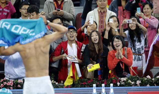 Fans watch Spain's Rafael Nadal change his shirt after he defeated Philipp Kohlschreiber of Germany in their match at the China Open tennis tournament in Beijing October 2, 2013. (Photo by Kim Kyung-Hoon/Reuters)