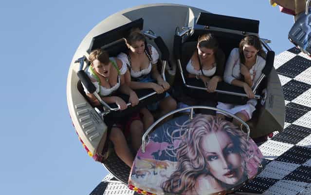 Young women enjoy a fairground ride at the 180th Bavarian [Oktoberfest] beer festival in Munich, southern Germany, Wednesday, October 2, 2013. One of the world's largest beer festival to be held from Sept. 21 to October 6, 2013 will attract more than six million guests from around the world. (Photo by Matthias Schrader/AP Photo)