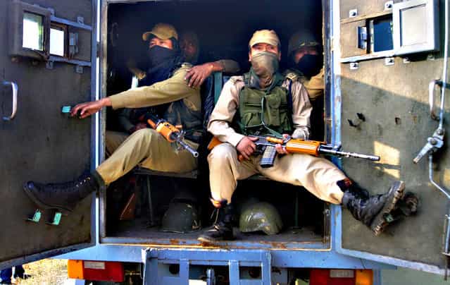 Indian paramilitary soldiers sit inside an armored vehicle near the site of a gun-battle in the outskirts of Srinagar, India, Thursday, October 3, 2013. Police said that at least seven policemen were wounded in an overnight gun-battle with suspected militants in the city of Srinagar. Police further said that militants managed to escape from the security cordon in the city. (Photo by Dar Yasin/AP Photo) Indian paramilitary soldiers sit inside an armored vehicle near the site of a gun-battle in the outskirts of Srinagar, India, Thursday, October 3, 2013. Police said that at least seven policemen were wounded in an overnight gun-battle with suspected militants in the city of Srinagar. Police further said that militants managed to escape from the security cordon in the city. (Photo by Dar Yasin/AP Photo)