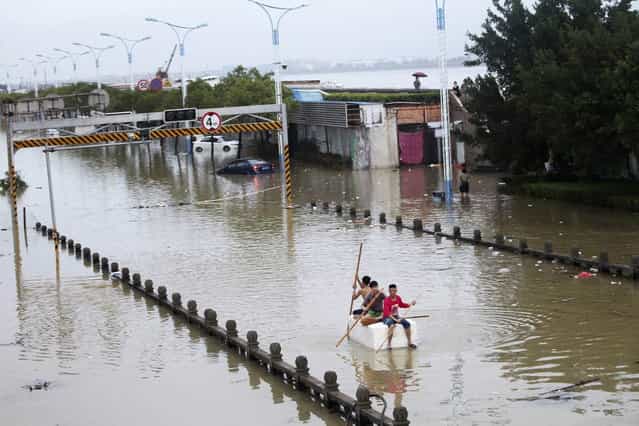 Residents paddle a makeshift raft as they make their way along a flooded street after Typhoon Fitow hit Rui'an, Zhejiang province October 7, 2013. Typhoon Fitow has affected the lives of 4.56 million people in east China's Zhejiang and Fujian provinces, the State Flood Control and Drought Relief Headquarters said on Monday, Xinhua News Agency reported. (Photo by Reuters/Stringer)