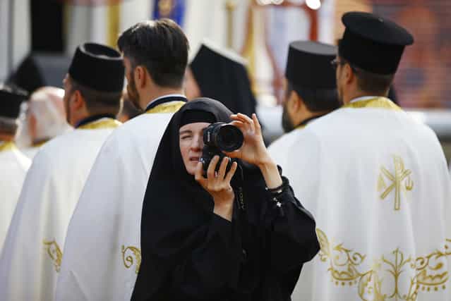 A nun takes pictures as believers mark 1,700 years since the Edict of Milan, when Roman emperor Constantine issued instructions to end the persecution of Christians, in the southern Serbian city of Nis October 6, 2013. Nis, some 220 km (137 miles) south of Belgrade, is the birthplace of Constantine the Great, the first Roman emperor to convert to Christianity. The Edict of Milan, which he had a part in enacting, proclaimed official tolerance of Christianity across the Empire. (Photo by Marko Djurica/Reuters)