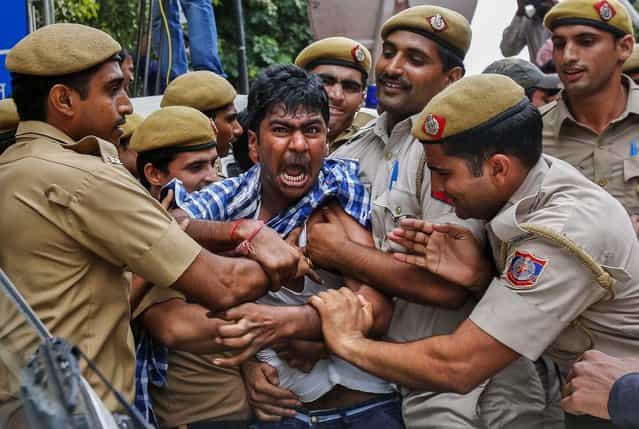 Police detain a supporter of Chandrababu Naidu, chief of Telugu Desam Party as he tries to stop a vehicle from carrying Naidu to a hospital in New Delhi, on Oktober 11, 2013. Naidu has been on a hunger strike since Monday against the creation of Telangana state, according to local media. Two Indian ministers resigned last week over a cabinet decision to create the new state out of the southern Indian state of Andhra Pradesh, a growing hub for Western IT giants. (Photo by Mansi Thapliyal/Reuters)