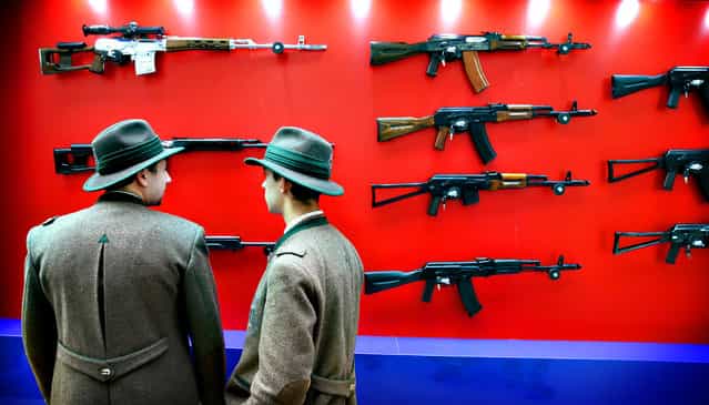 Visitors look at Kalashnikov automatic rifles during the Arms and Hunting Exhibition in Moscow, Russia, 10 October 2013. The exhibition that runs from 10 to 13 October 2013. (Photo by Yuri Kochetkov/EPA)