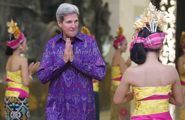 US Secretary of State John Kerry, welcomed by Indonesian beauties, gestures while arriving with Russian President Vladimir Putin (L) for a group photo at Asia-Pacific Economic Cooperation (APEC) Summit in Nusa Dua, Bali, Indonesia, 7 October 2013. (Photo by Sergei Chirikov/EPA)