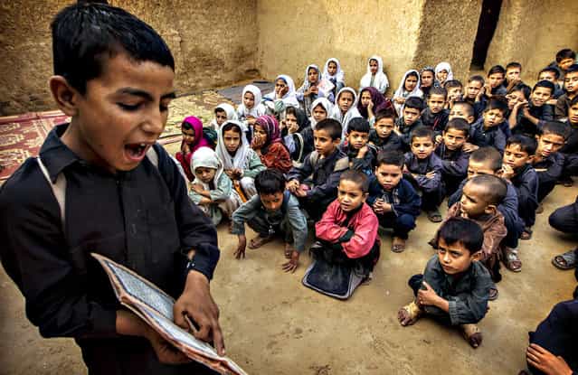 A boy recites from a book during a lesson at a school in a slum on the outskirts of Islamabad October 11, 2013. (Photo by Zohra Bensemra/Reuters)