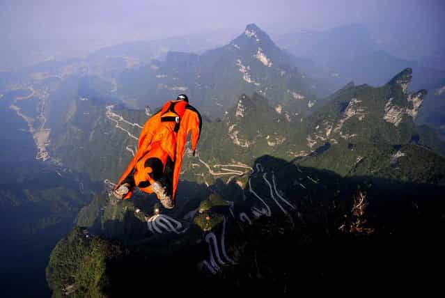 Hungarian wingsuit flier Viktor Kovats jumps off a mountain at Tianmen Mountain National Forest Park in Zhangjiajie, China, on Oktober 9, 2013. Kovats died during this fatal jump into a gorge. His body was recovered Wednesday from the steep, forested valley floor at the park, state broadcaster CCTV said. The reports said the highly experienced Kovats apparently died from a head injury after crashing into a cliff-side. His 2,290-foot jump was part of preparations for the Second World Wingsuit Championship being held in the park from October 11 to 13. (Photo by Associated Press)