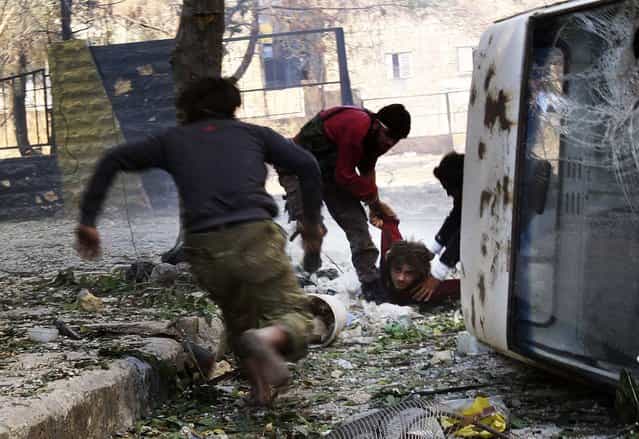 [Free Syrian Army] fighters rush to help their fellow fighter after he was shot by a sniper loyal to Syria's President Bashar al-Assad in Aleppo's Salaheddine neighborhood, on Oktober 9, 2013. (Photo by Ammar Abdullah/Reuters)