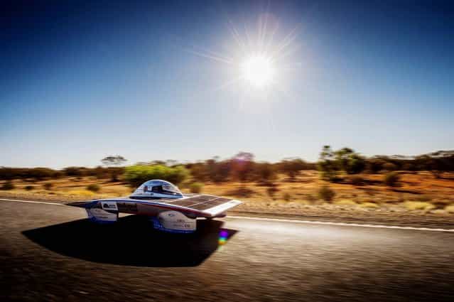 The Indupol One of the Belgian solar team rides across a desert, 285 kilometers south of Alice Springs, Australia, on Oktober 8, 2013. The solar challenge race, lasting for seven days, will take 43 participants over 3,021 kilometers before ending on Sunday. (Photo by Geert Vanden Wijngaert/Associated Press)