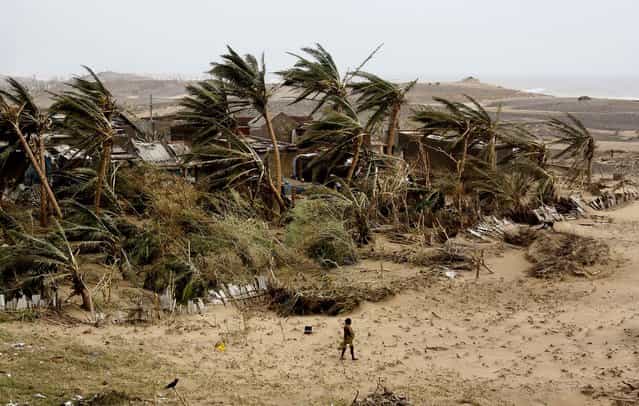 A woman returns to the cyclone hit Arjipalli village on the Bay of Bengal coast in Ganjam district, as India began sorting through miles of wreckage Sunday after Cyclone Phailin roared ashore, flooding towns and villages and destroying tens of thousands of thatch homes, but officials said massive evacuation efforts had spared the east coast from widespread loss of life. (Photo by Biswaranjan Rout/Associated Press)
