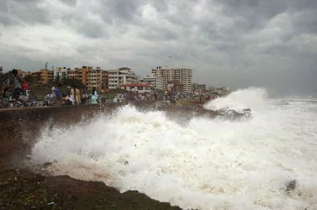 Indian people watch high tide waves as they stand at the Bay of Bengal coast in Vishakhapatnam, India, Saturday, October 12, 2013. Hundreds of thousands of people living along India's eastern coastline were taking shelter Saturday from a massive, powerful cyclone Phailin that was set to reach land packing destructive winds and heavy rains. (Photo by AP Photo)