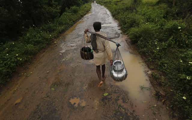 A man carrying his belongings walks towards a safer place at the village Donkuru in Srikakulam district in the southern Indian state of Andhra Pradesh October 12, 2013. Rain and wind lashed India's east coast on Saturday, forcing more than 400,000 people to flee to storm shelters as one of the country's largest cyclones closed in, threatening to cut a wide swathe of devastation through farmland and fishing hamlets. Filling most of the Bay of Bengal, Cyclone Phailin was about 200 km (124 miles) offshore by noon on Saturday, satellite images showed, and was expected to hit land by nightfall. (Photo by Adnan Abidi/Reuters)