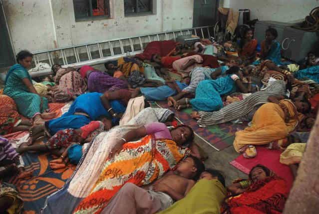 Indian residents rest in a cyclone shelter near Gopalpur, about 190 kms from the eastern city Bhubaneswar on October 11, 2013. India issued a red alert as a massive cyclone bore down on the east coast October 12 forcing the evacuation of hundreds of thousands of people, officials said. (Photo by Asit Kumar/AFP Photo)