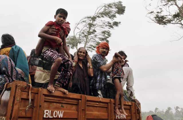 Evacuated Indian villagers get down from a truck at a relief camp as it rains near Berhampur, India, Saturday, October 12, 2013. Hundreds of thousands of people living along India's eastern coastline were taking shelter Saturday from a massive, powerful cyclone Phailin that was set to reach land packing destructive winds and heavy rains. (Photo by Bikas Das/AP Photo)