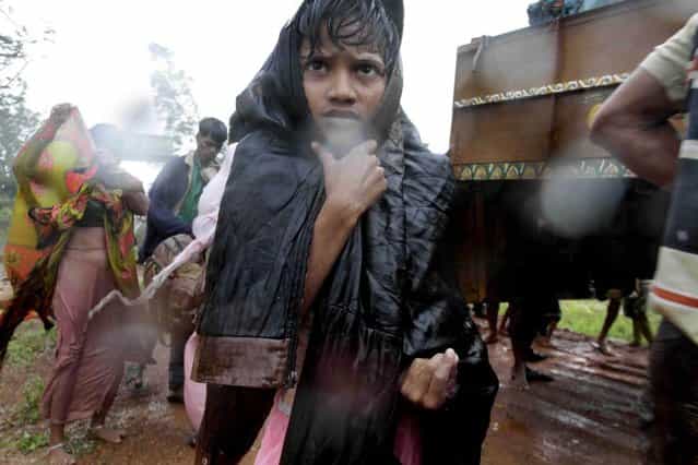 A younh Indian boy reaches a relief camp after being evacuated as it rains near Berhampur, India, Saturday, October 12, 2013. Hundreds of thousands of people living along India's eastern coastline were taking shelter Saturday from a massive, powerful cyclone Phailin that was set to reach land packing destructive winds and heavy rains. (Photo by Bikas Das/AP Photo)
