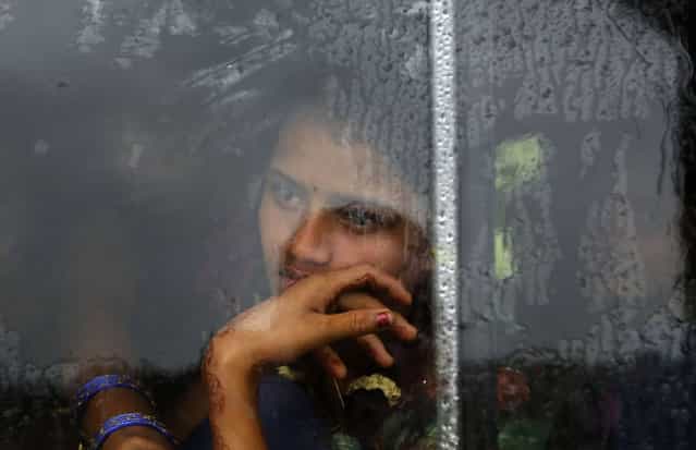 A girl looks out from the window of a bus travelling towards a relief camp in Donkuru village in Srikakulam district in the southern Indian state of Andhra Pradesh October 12, 2013. (Photo by Adnan Abidi/Reuters)