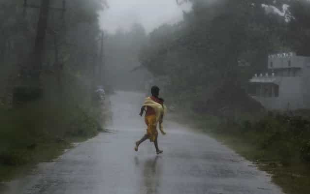 A girl runs for shelter in heavy rain brought by Cyclone Phailin in Ichapuram town in Srikakulam district in the southern Indian state of Andhra Pradesh October 12, 2013. (Photo by Adnan Abidi/Reuters)