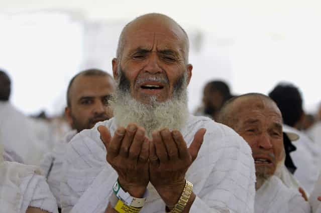 An Afghani Muslim pilgrim prays after he casts stones at a pillar, symbolizing the stoning of Satan, in a ritual called [Jamarat], the last rite of the annual hajj, in the Mina neighborhood of Mecca, Saudi Arabia, Tuesday, October 15, 2013. The 10th day of the Islamic lunar month of Dhul-Hijja, during the hajj, is the beginning of Eid al-Adha, the most important Islamic holiday, to mark the willingness of the Prophet Ibrahim, or Abraham to Christians and Jews, to sacrifice his son. (Photo by Amr Nabil/AP Photo)
