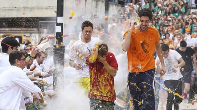 Faculty of medicine first year students run while seniors spray them with different types of sauces, liquids, flour and eggs as part of an annual tradition during a celebration in honour of their patron Saint Lucas at Granada University in Granada, southern Spain October 17, 2013. (Photo by Pepe Marin/Reuters)