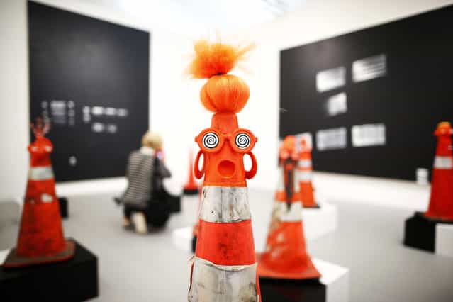 A visitor photographs part of Robert Pruitt's [Safety Cones] at the Gavin Brown's Enterprise from New York's stand at the Frieze Art Fair in central London, October 16, 2013. (Photo by Andrew Winning/Reuters)