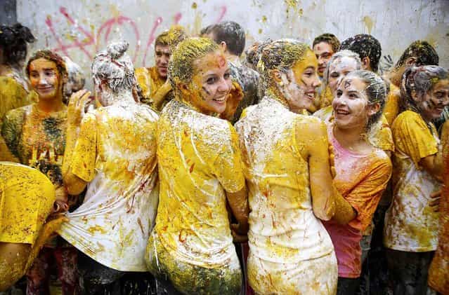 Faculty of medicine first year students are seen after seniors sprayed them with different types of sauces, liquids, flour and eggs as part of an annual tradition during a celebration in honor of their patron Saint Lucas, at Granada University in Granada, Spain, on Oktober 17, 2013. (Photo by Pepe Marin/Reuters)