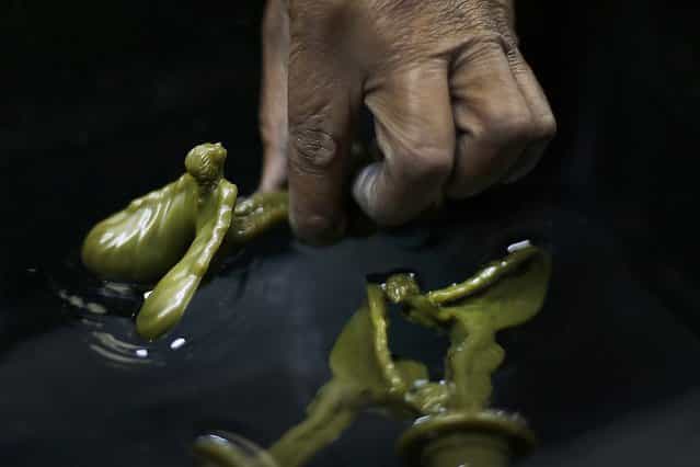 Moore cools a wax form. (Photo by Stefan Wermuth/Reuters)