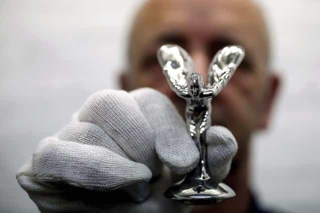 Worker Ronald Little displays a finished [Spirit of Ecstasy]. (Photo by Stefan Wermuth/Reuters)