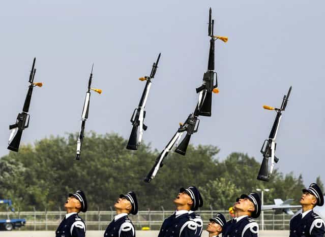 The South Korean Air Force honor guard throw their guns in the air during a press day for an air show at the Seoul International Aerospace & Defense Exhibition which will be held from October 25 to November 3, at Cheongju International Airport in Cheongju, south of Seoul, South Korea, on Oktober 24, 2013. (Photo by Lee Jin-man/Associated Press)