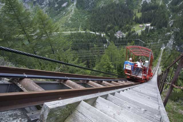 These are the stomach-churning pictures of Europe's steepest funicular which has a gradient of 106 per cent - but not a seatbelt in sight. The breathtaking images show two children clutching onto a single rail as the ground drops away beneath them in Bern, Switzerland, on Oktober 20, 2013. (Photo by Caters News Agency)