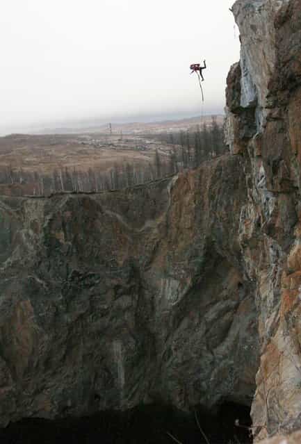 A member of the [Exit Point] amateur rope-jumping group takes a rope jump from a 120-metre high rock down to a man-made crater called [Tuimsky Proval] outside the town of Tuim in Khakassia region, Russia, on Oktober 22, 2013. (Photo by Ilya Naymushin/Reuters)