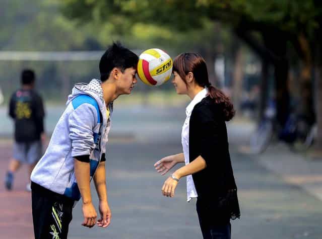 Students carry a volleyball using their foreheads in a game for improving cooperation at a campus in Wuhan, on Oktober 21, 2013. (Photo by Reuters)