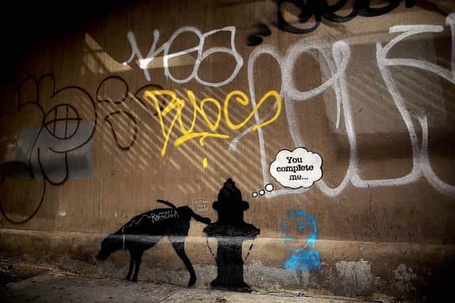 A Bansky work on a side of a NYC wall is seen on October 3, 2013. Several of his works have quickly been vandalized by other graffiti. (Photo by Spencer Platt/Getty Images)