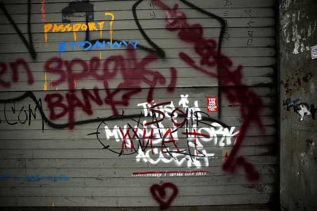 Banksy's work, [This is My New York Accent], is seen on October 3, 2013 after being vandalized by other graffiti. (Photo by Spencer Platt/Getty Images)