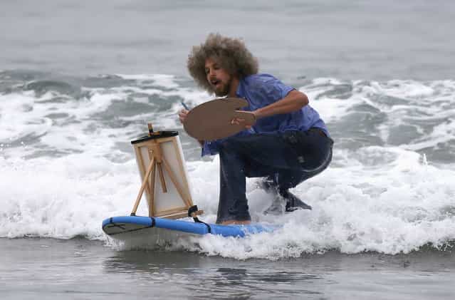 David Nickerson, 28, competes dressed as artist Bob Ross, during the ZJ Boarding House Halloween Surf Contest in Santa Monica, California October 26, 2013. (Photo by Lucy Nicholson/Reuters)