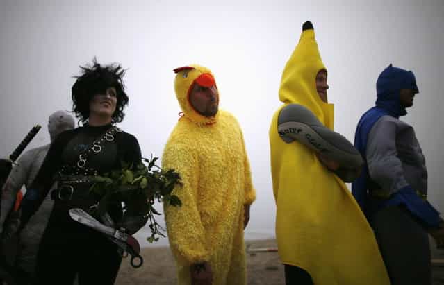 Competitors line up to surf in the ZJ Boarding House Halloween Surf Contest in Santa Monica, California October 26, 2013. (Photo by Lucy Nicholson/Reuters)
