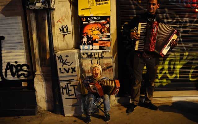 Father and son perform in the street of Istanbul, Turkey, on Oktober 28, 2013. (Photo by Bulent Kilic/AFP Photo)