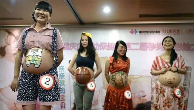Pregnant women show off paintings on their bellies during a body painting contest for pregnant women in Chongqing municipality, October 27, 2013. Over 30 pregnant women participated in the contest, according to local media. (Photo by Reuters/China Daily)