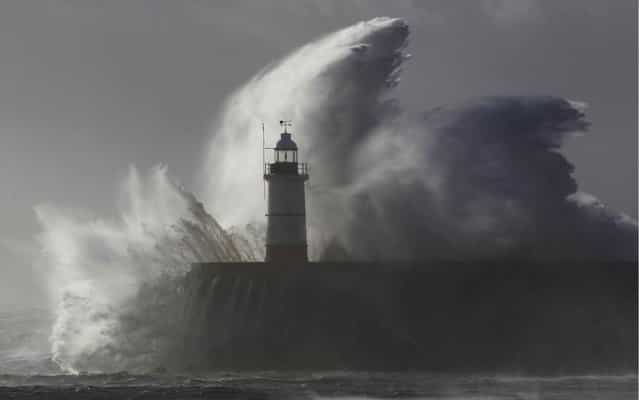 Waves crash against a lighthouse during storms that battered Britain and where a 14-year-old boy was swept away to sea at Newhaven in South East England October 28, 2013. Britain's strongest storm in a decade battered southern regions on Monday, forcing hundreds of flight cancellations, cutting power lines and disrupting the travel plans of millions of commuters. Police said rescuers were forced to call off a search for the boy late on Sunday due to the pounding waves, whipped up by the rising wind. (Photo by Luke MacGregor/Reuters)