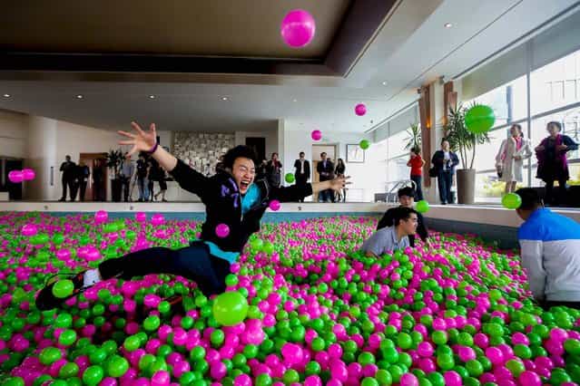 A man jumps in a swimming pool filled with pink and green plastic balls during a Guinness World Records attempt of the Largest Ball Pit as part of the [Pink October] campaign at Kerry Hotel in Pudong, Shanghai, on Oktober 30, 2013. The event, aimed at raising awareness of breast cancer prevention, set the world record with one million balls in the 82 by 41 foot swimming pool. (Photo by Aly Song/Reuters)