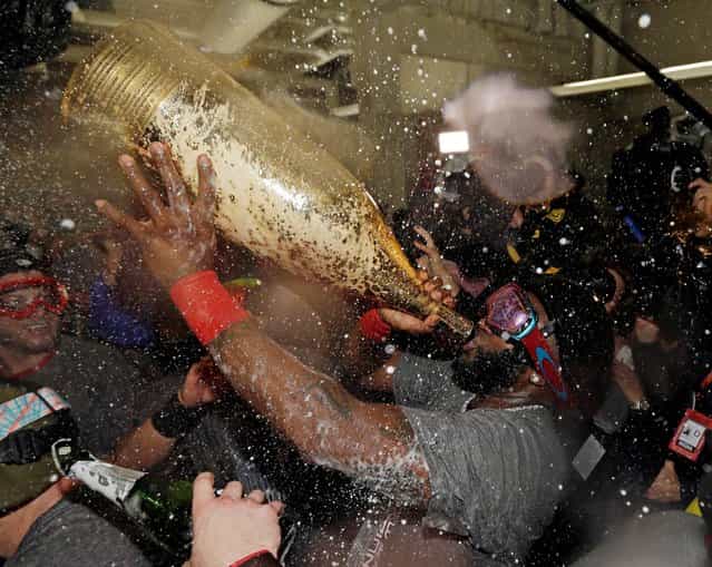 Boston Red Sox's David Ortiz drinks out of a giant bottle of Champagne as he celebrates with teammates after Game 6 of baseball's World Series against the St. Louis Cardinals Thursday, Oct. 31, 2013, in Boston. The Red Sox won 6-1 to win the series. Ortiz was names the series MVP. (Photo by David J. Phillip/AP Photo)
