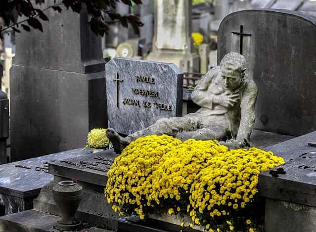 A statue sits on top of a gravestone at the Campo Santo cemetery in Ghent, western Belgium, on Oktober 31, 2013. The 19th century cemetery is acknowledged as one of the most renowned and beautiful cemeteries in Belgium, with more than 130 gravestones listed as protected monuments. (Photo by Yves Logghe/Associted Press)