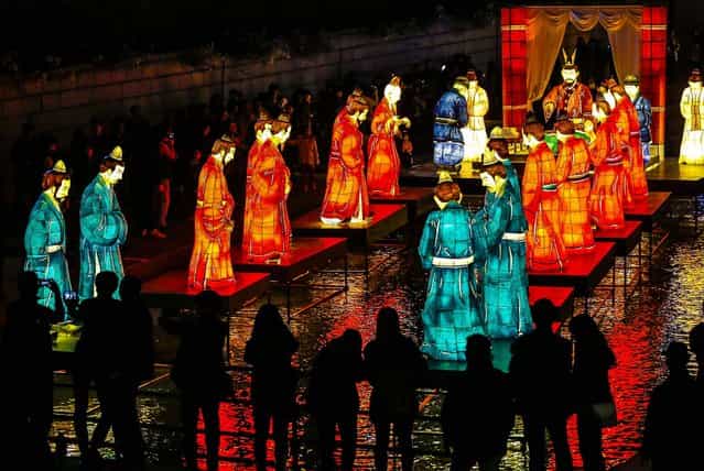 People look at lanterns depicting the government rank system and uniforms from the Baekje period during the Seoul Lantern Festival 2013 at Cheonggye stream in central Seoul, South Korea, on November 1, 2013. (Photo by Kim Hong-Ji/Reuters)