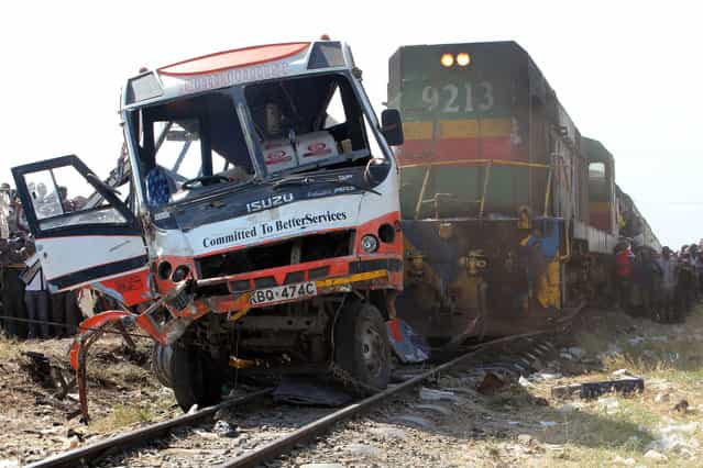 The wreckage of a minibus that was involved in an accident with a passenger train in Nairobi is pictured on October 30, 2013. At least twelve people were killed and several others injured on October 30, 2013 when a passenger train in Kenya's capital smashed into a bus at a crossing, Red Cross officials said. (Photo by Simon Maina/AFP Photo)