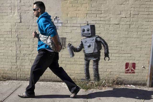 The newest installation by British artist Banksy, a robot and a barcode, is seen on a wall in the Coney Island area of New York City, on Oktober 28, 2013. Famously jaded New Yorkers are getting swept up in the hype over Banksy, the renegade graffiti artist who is leaving his mark across the city this month. (Photo by Brendan McDermid/Reuters)