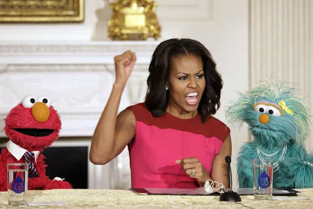 U.S. first lady Michelle Obama reacts between PBS Sesame Street characters Elmo and Rosita after delivering remarks on marketing healthier foods to children at the White House in Washington October 30, 2013. Michelle Obama invited local schoolchildren to participate in the fall harvest of the White House Kitchen Garden. (Photo by Yuri Gripas/Reuters)