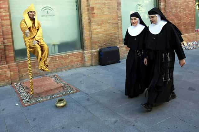 Two nuns walk past a street mime in the Andalusian capital of Seville, Spain, on Oktober 30, 2013. (Photo by Marcelo del Pozo/Reuters)