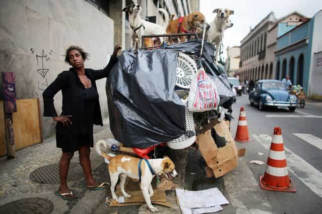 Rosana Moses stands with the family of 16 dogs she cares for in Rio de Janeiro, Brazil. She lives on the streets and relies on donations to help care for the dogs, on Oktober 30, 2013. (Photo by Mario Tama/Getty Images)