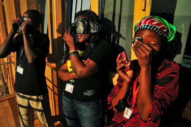 Ugandans watch a hybrid solar eclipse in Kampala. (Photo by Stephen Wandera/Associated Press)