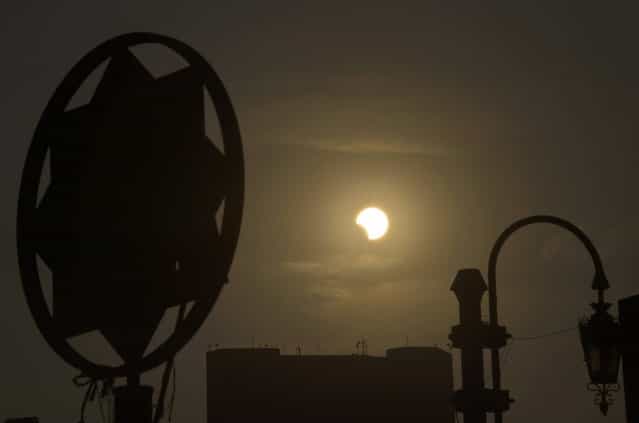 A partial solar eclipse is seen over the Egyptian capital Cairo, on November 3, 2013. The rare solar eclipse will sweep across parts of Africa, Europe and the United States as the moon blocks the sun either fully or partially, depending on the location. (Photo by Khaled Desouki/AFP Photo)