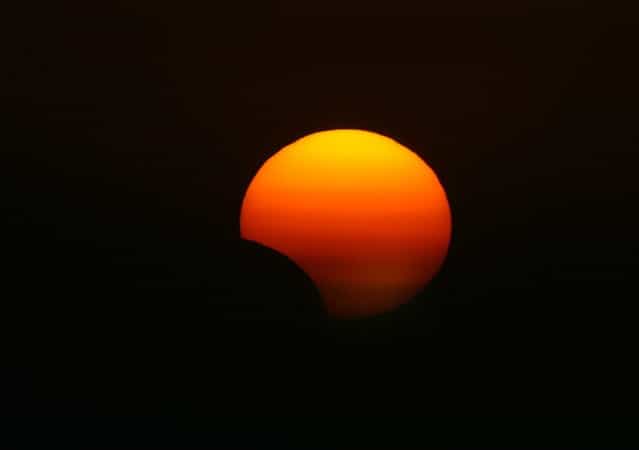 This picture taken on November 3, 2013 shows a rare hybrid solar eclipse, in the northern Iraqi city of Arbil. The rare solar eclipse will sweep across parts of Africa, Europe and the United States as the moon blocks the sun either fully or partially, depending on the location. (Photo by Safin Hamed/AFP Photo)