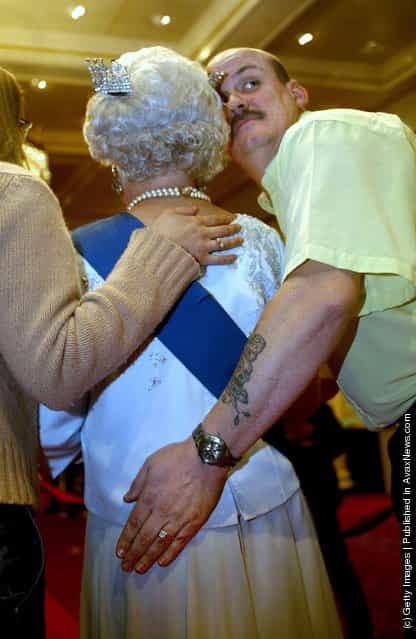 Tourist Nick Travis pats the behind of a new waxwork model of the Britains Queen Elizabeth